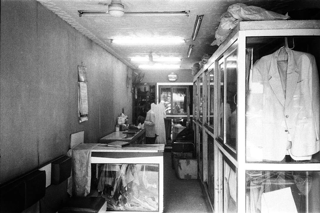 services-01 Groupe de nettoyeurs en uniformes rouges passant la serpillière et essuyant une vitre dans une salle à manger moderne.